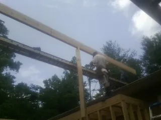 Carpenter setting a ridge beam over a new addition frame — Ice Dam Removal by Roofing Brothers in Little Mountain