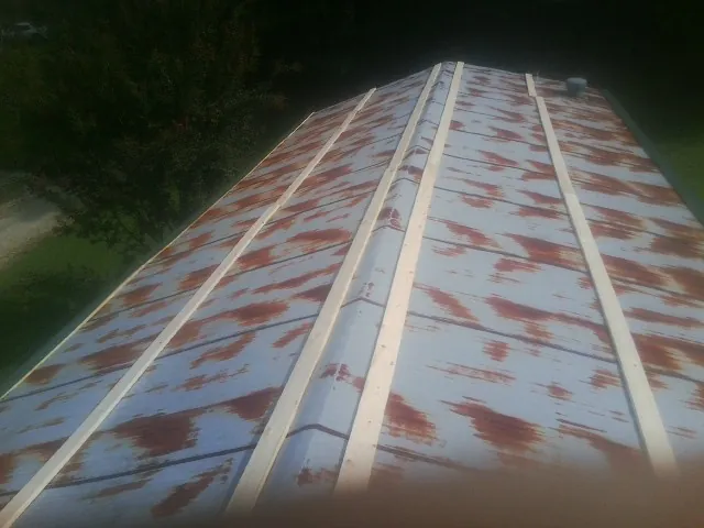 Rusted metal roof panels with new wood purlins before replacement — Storm Damage Roof Repair in Little Mountain by Roofing Brothers