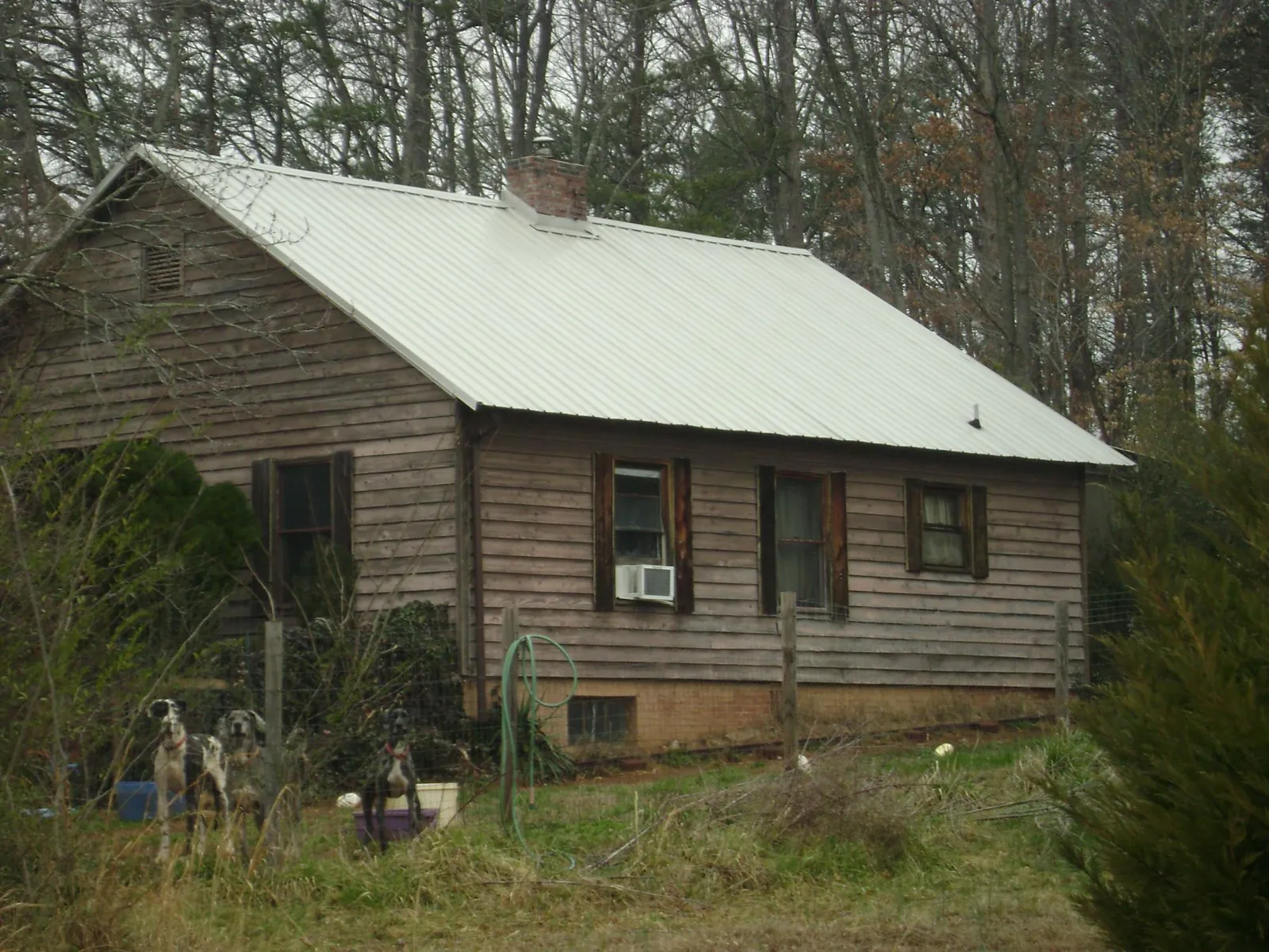White metal roof on an old wood sided farmhouse, from a Metal Roof Installation job in Little Mountain